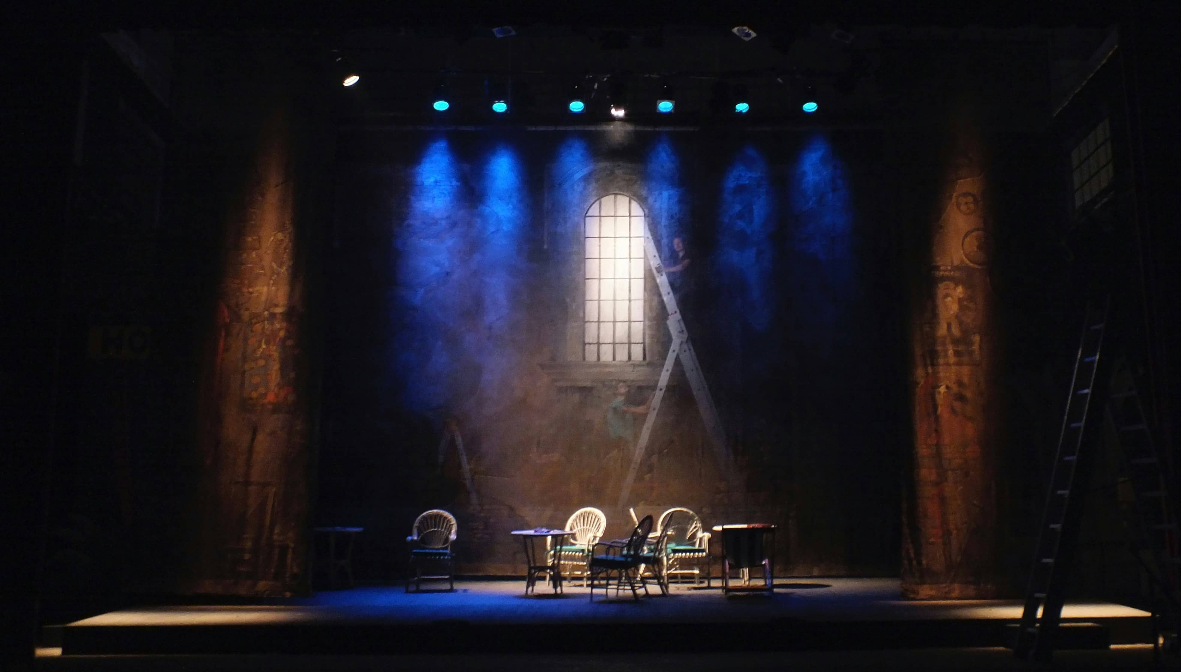 Teatterin esiintymislava, jossa pöytiä ja tuoleja